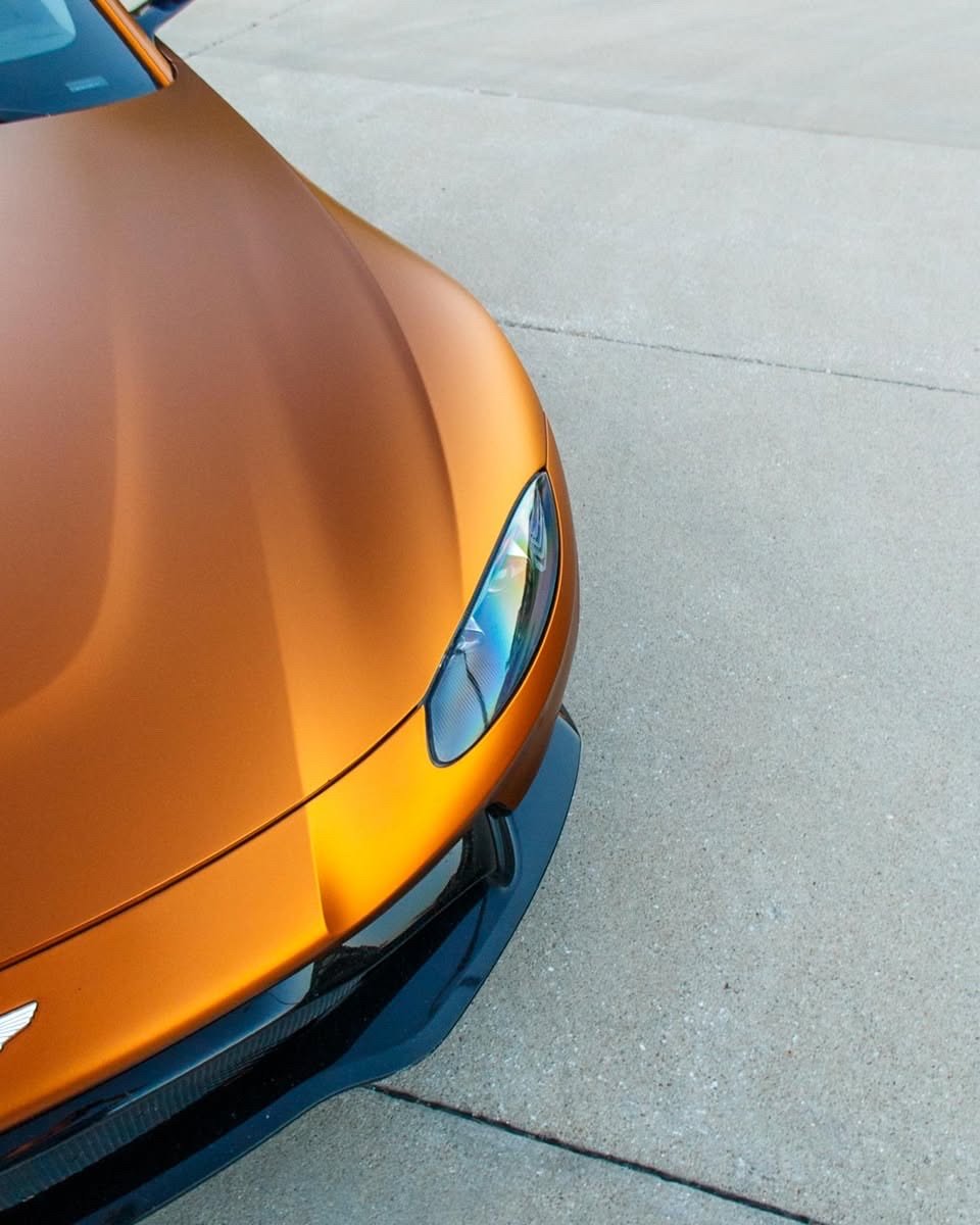 Matte orange Aston Martin Vantage hood and headlight close-up after an exterior detail in Altoona