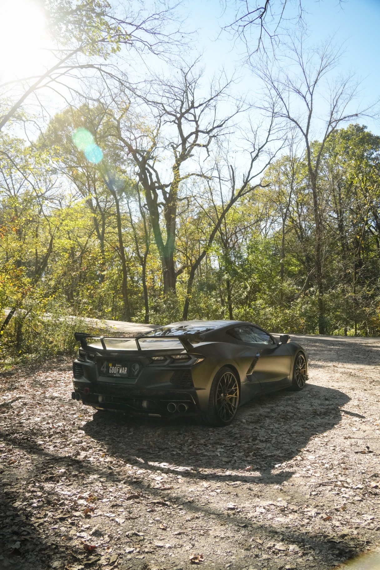 Black twin turbo Corvette C8 rear quarter on a wooded trail after a Premium Full Detail in Johnston