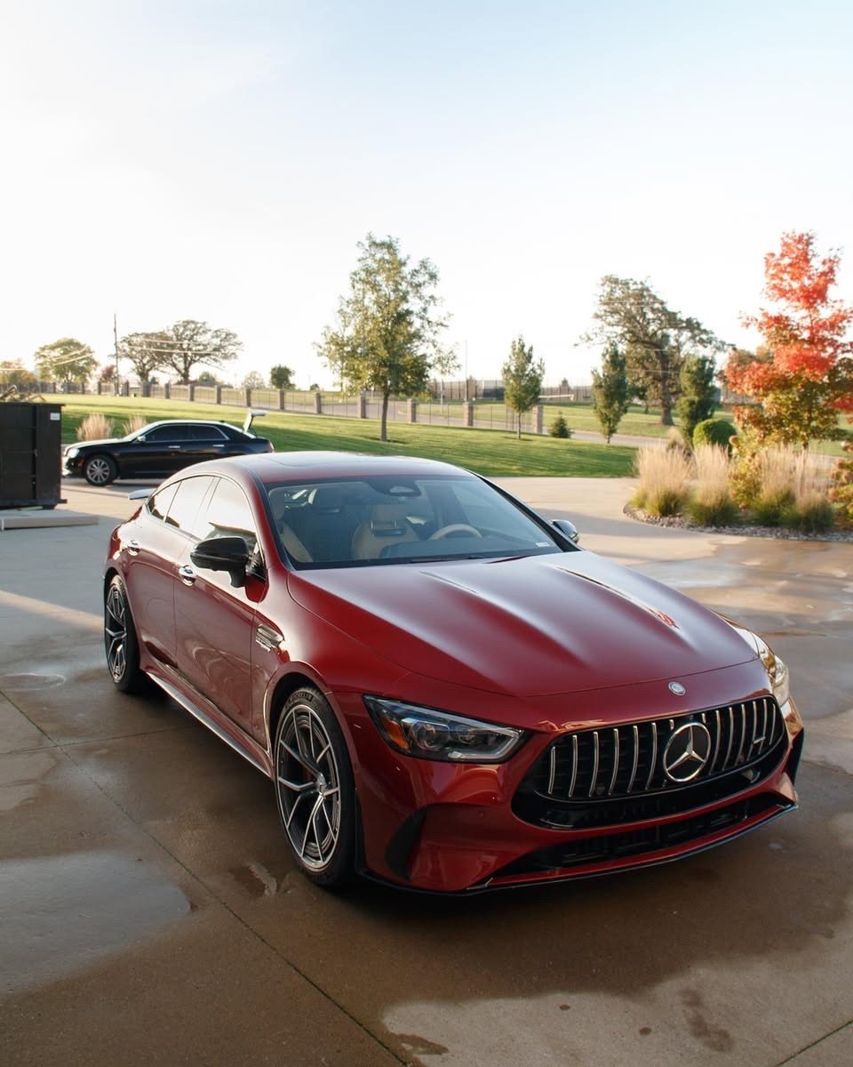 Finished red Mercedes-AMG GT 63 S front quarter with autumn trees in West Des Moines