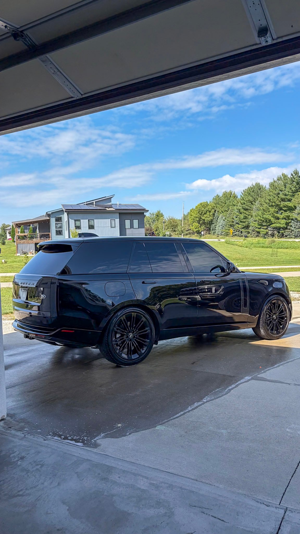 Black Range Rover framed by the open garage door after a full detail in West Des Moines