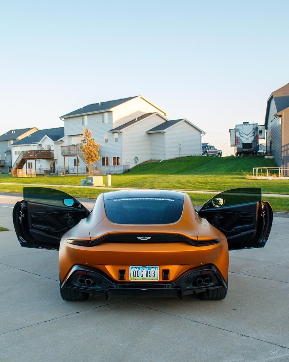 Matte orange Aston Martin Vantage rear with both doors open after an exterior detail in Altoona