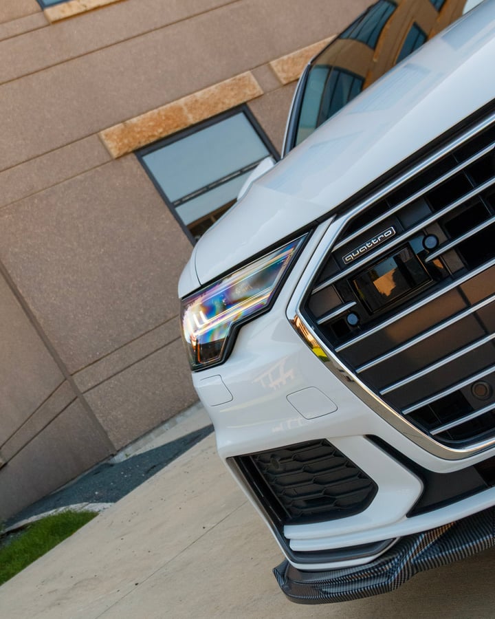 White Mercedes grille and headlight close-up photographed by Kenny