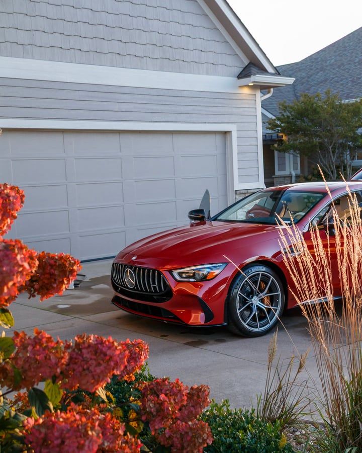 Red Mercedes-AMG sedan in a driveway photographed by Kenny