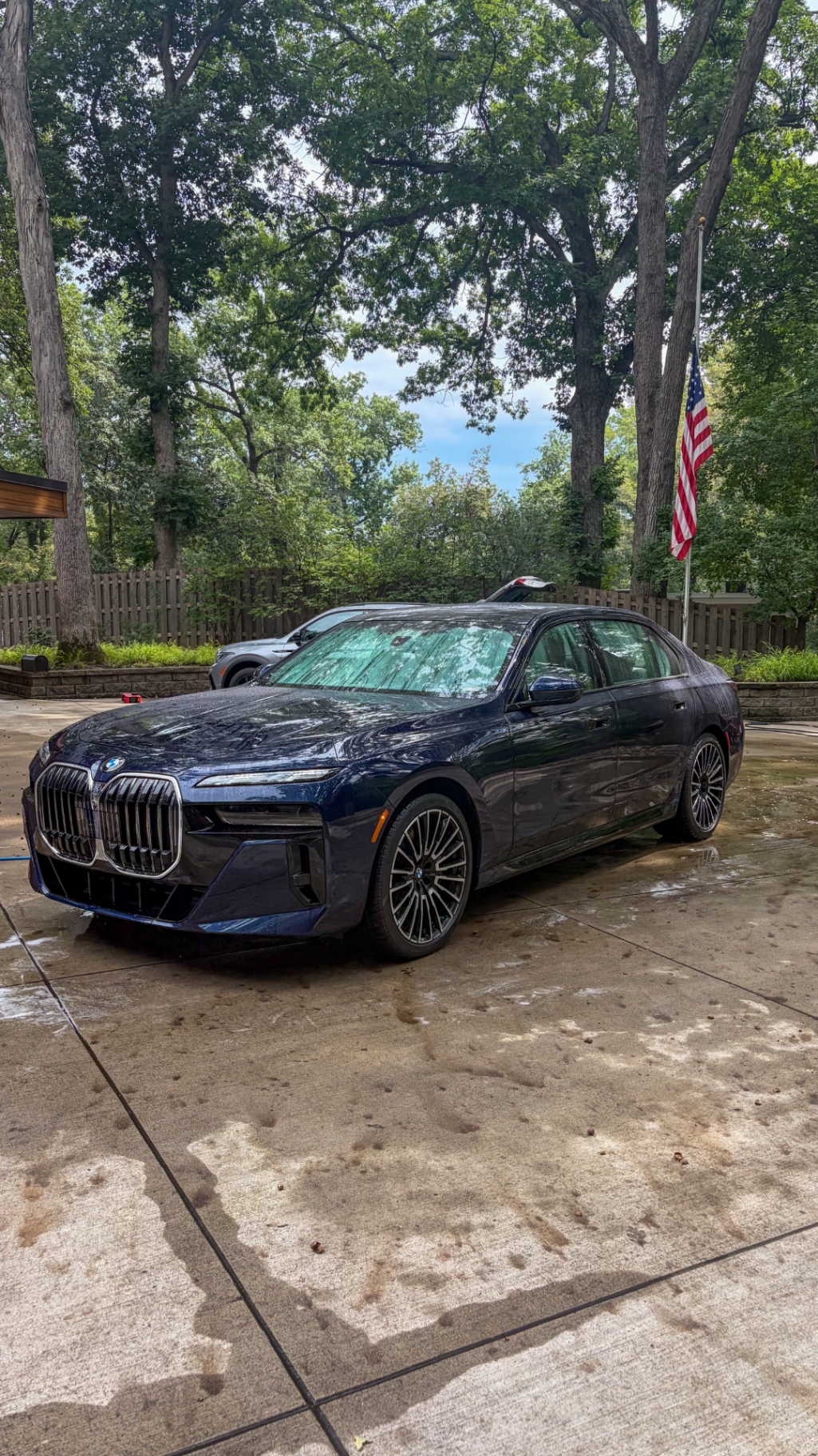 Front quarter of a BMW M760i xDrive detailed in the owner's driveway