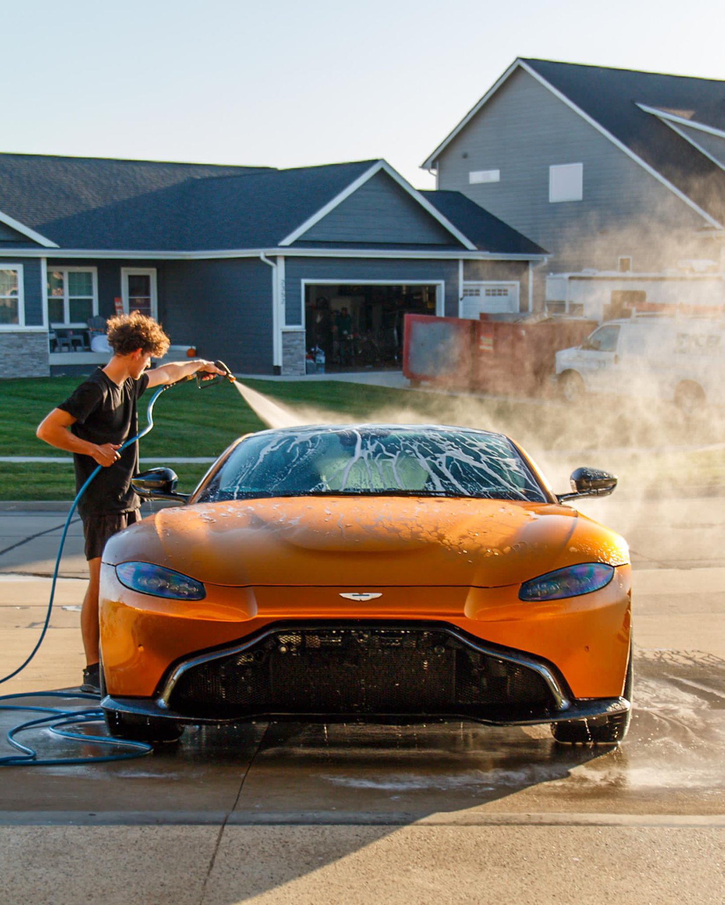 Jake rinsing the matte orange Aston Martin Vantage in Altoona