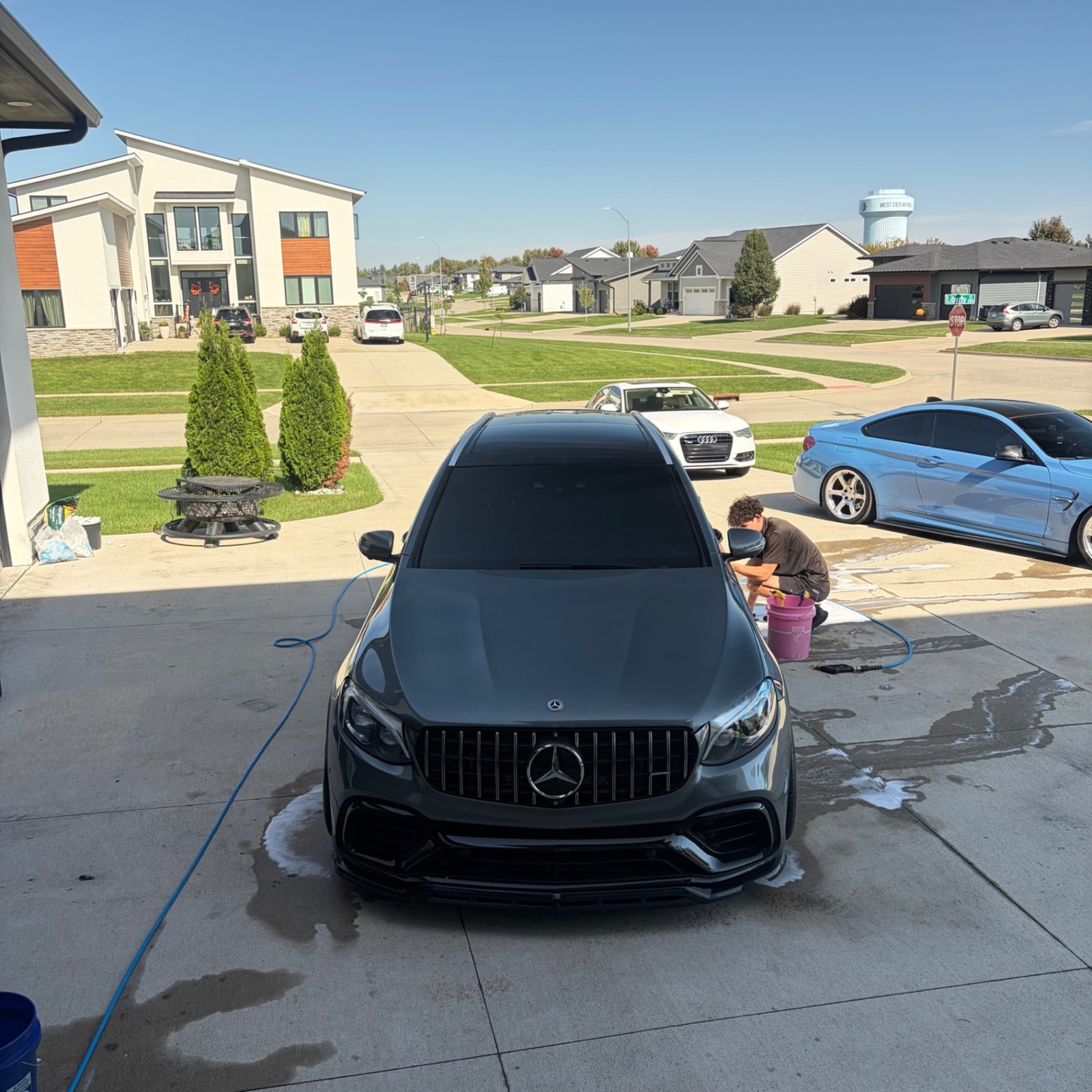 Jake washing a grey Mercedes-AMG GLC 63 in a West Des Moines driveway