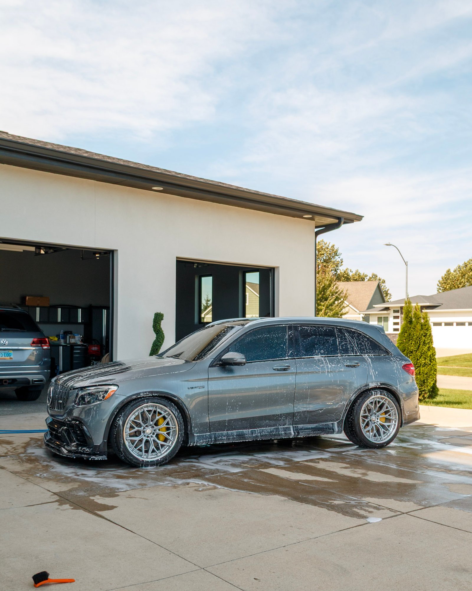 Grey Mercedes-AMG GLC 63 side profile in front of the garage