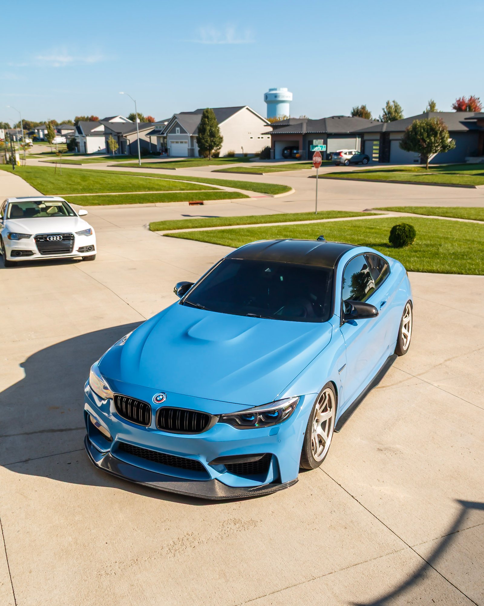 Light blue BMW M4 front three-quarter seen from above on the driveway