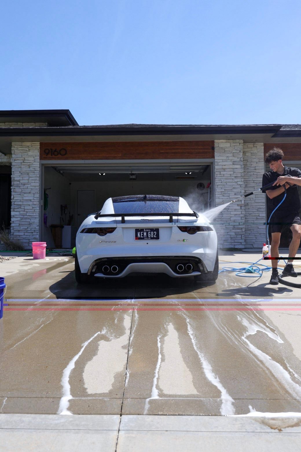 White Jaguar F-Type rear on a wet driveway during a full detail in West Des Moines