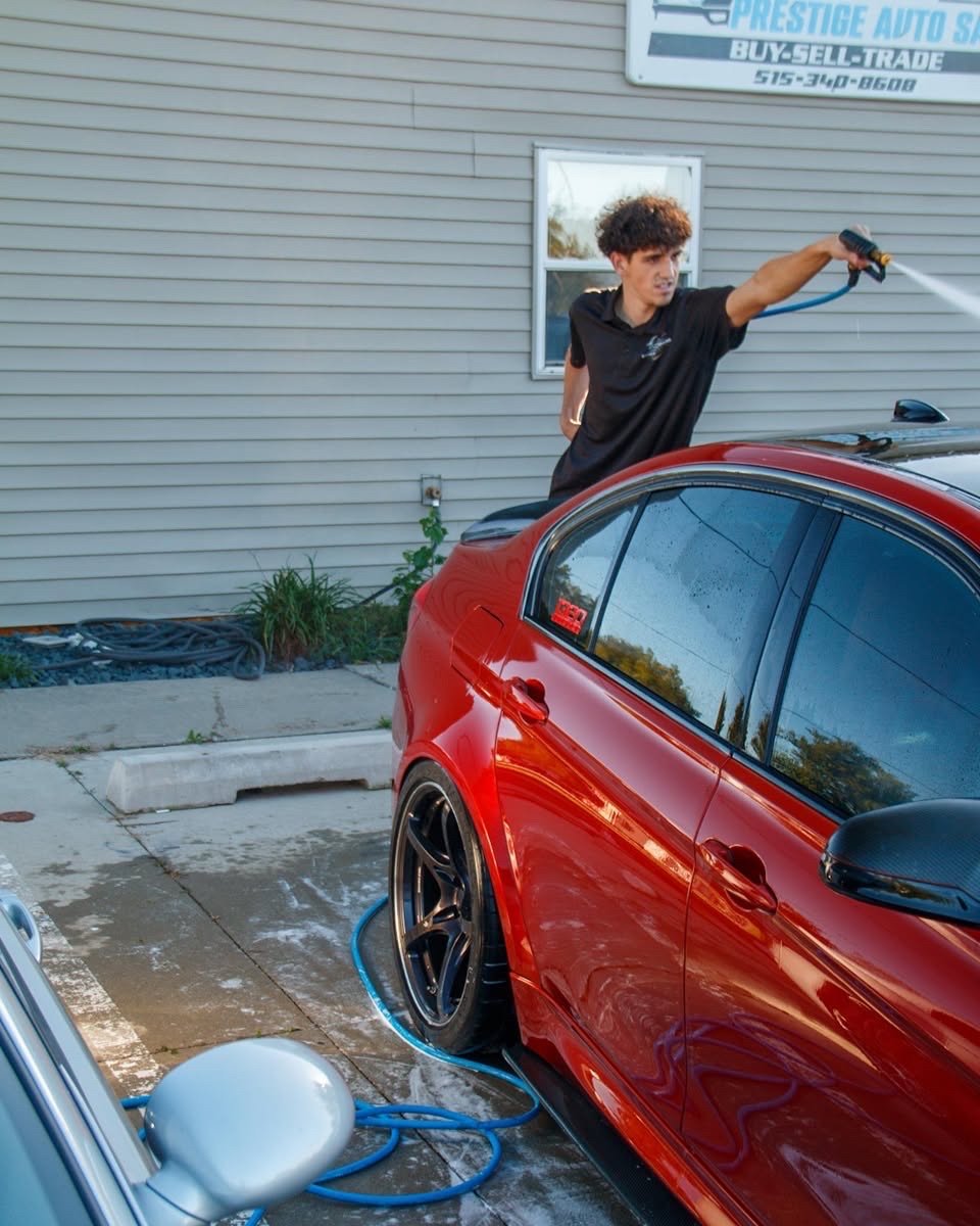 Jake rinsing the red BMW F80 M3 during its maintenance detail