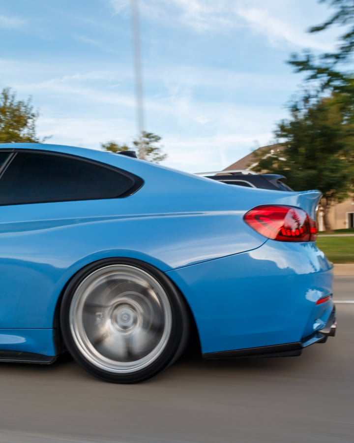Blue BMW rolling shot by Kenny, rear wheel spinning in motion