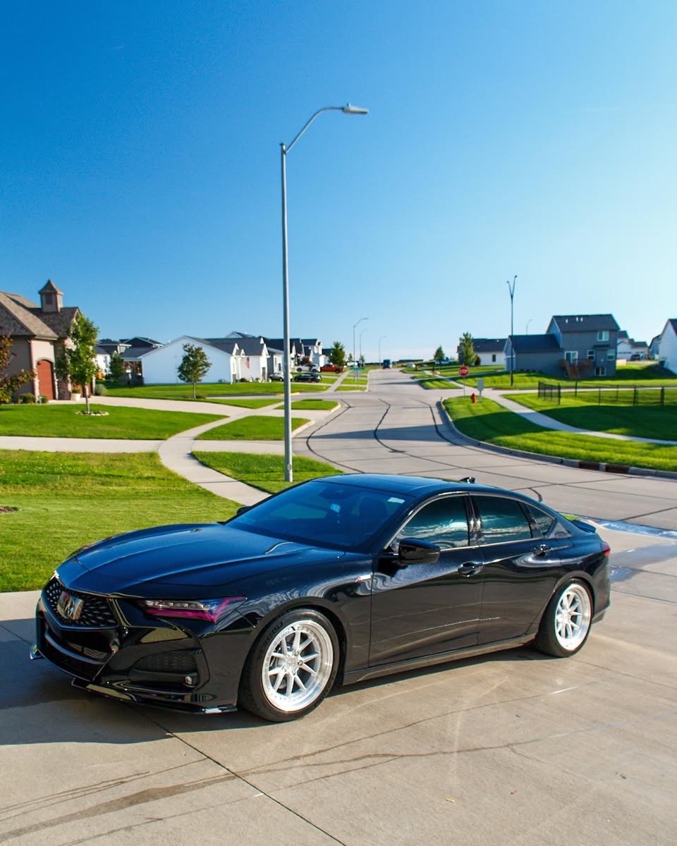 Black Acura TLX side profile in an Altoona driveway