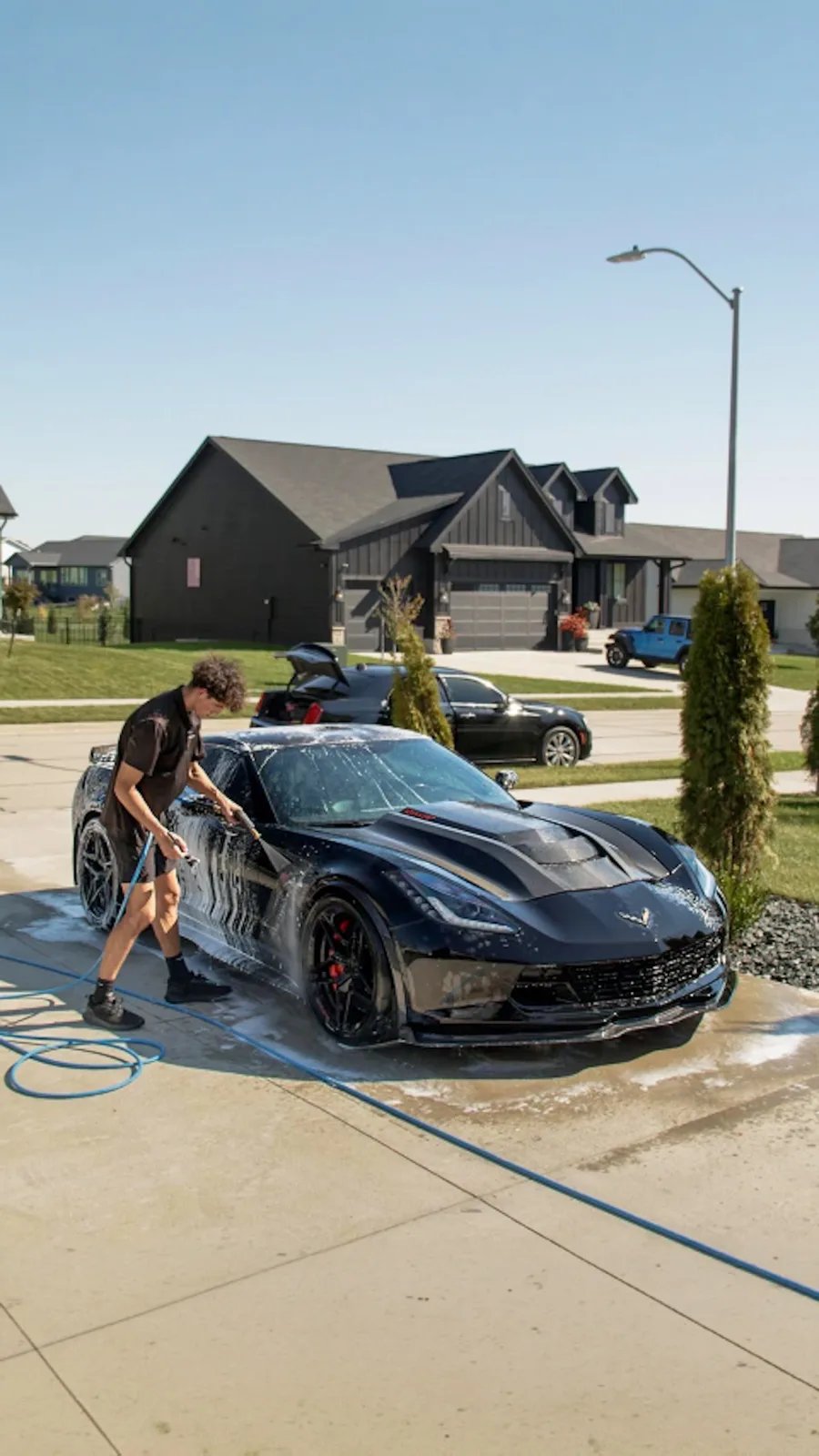Black 1,084 HP Corvette C7 Z06 Jake foam washing the Corvette in a Clive driveway