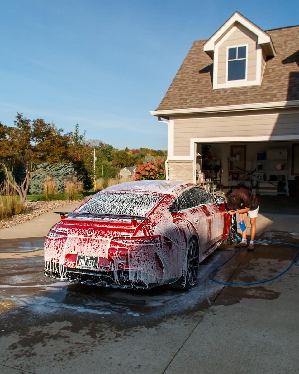 Jake foam washing the red Mercedes-AMG GT 63 S in the driveway