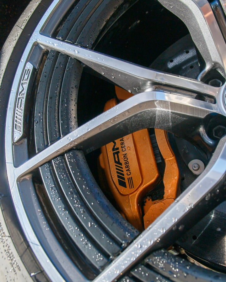 AMG carbon ceramic brake behind a wet wheel, photographed by Kenny